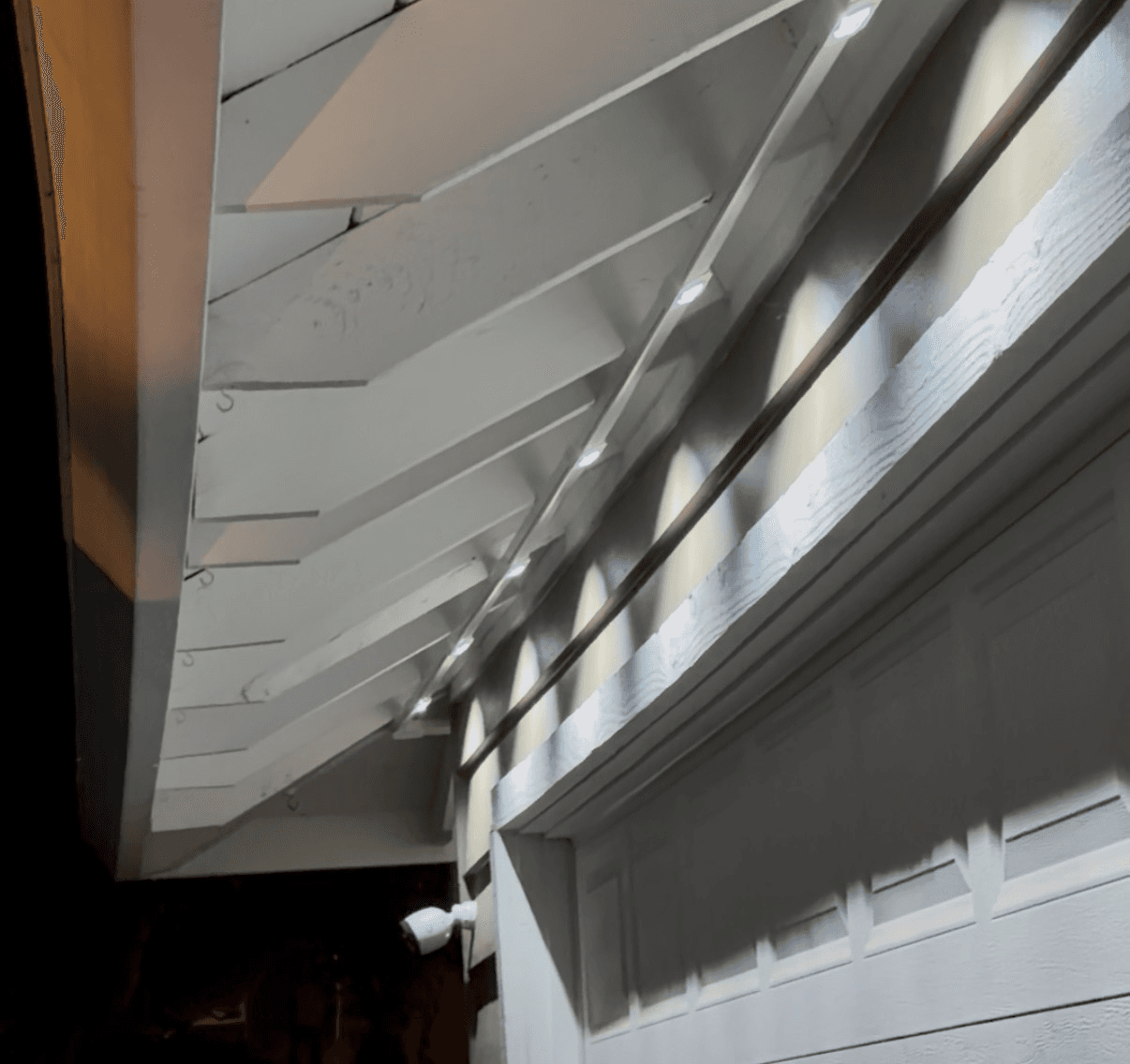 Close-up of PermTrack channel mounted along exposed California rafter tails with evenly-spaced Govee LEDs