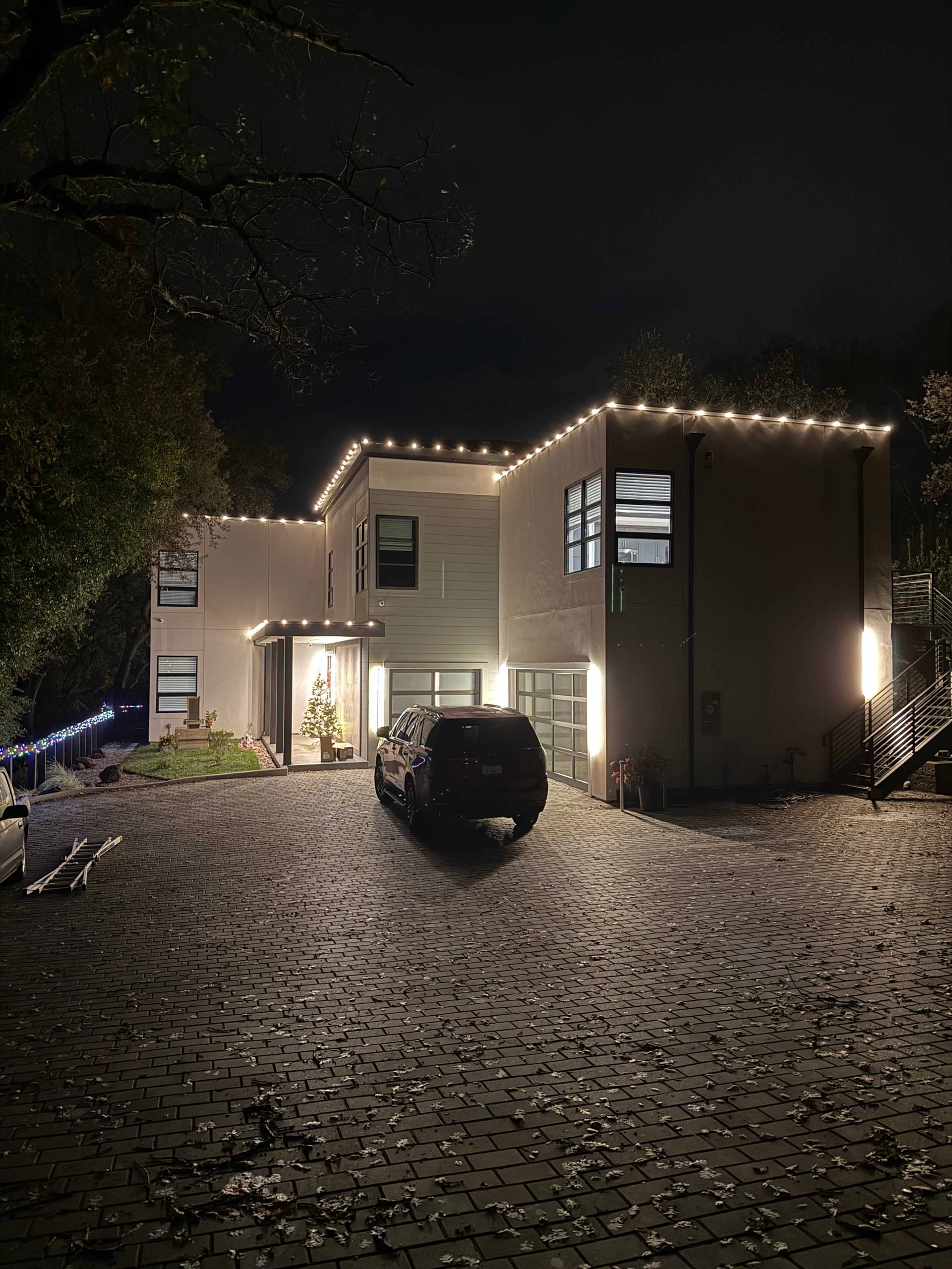 Clean warm white C9 roofline tracing the flat-roof edges of a contemporary two-story home