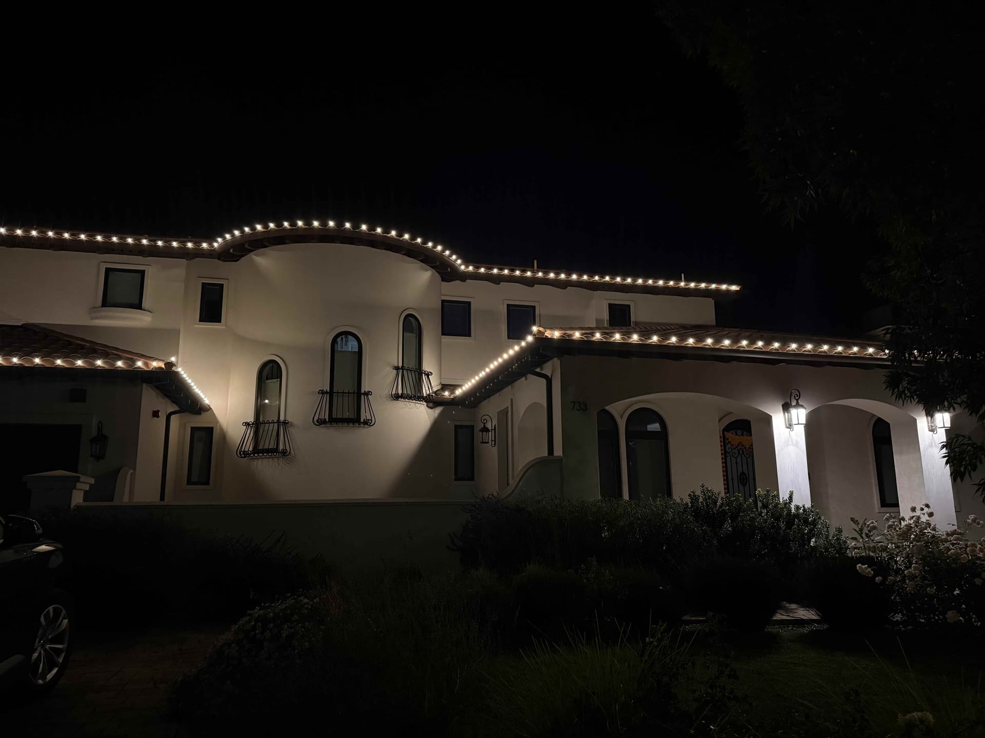 Spanish estate with warm-white C9 lights across every roofline and balcony rail