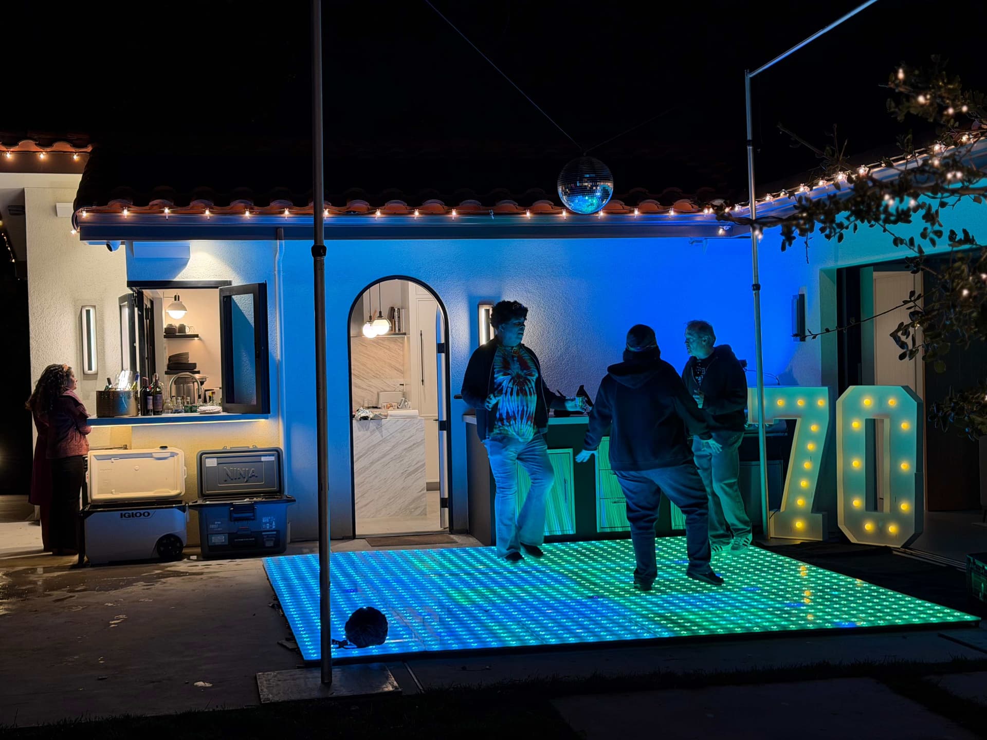 LED dance floor, disco ball, and marquee letters for a backyard celebration
